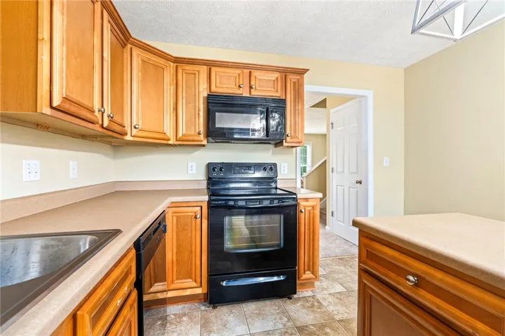 An inviting kitchen with warm wooden cabinetry and durable tile flooring awaits culinary creations.