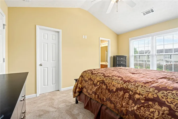A naturally illuminated bedroom with a high vaulted ceiling offers serene comfort.