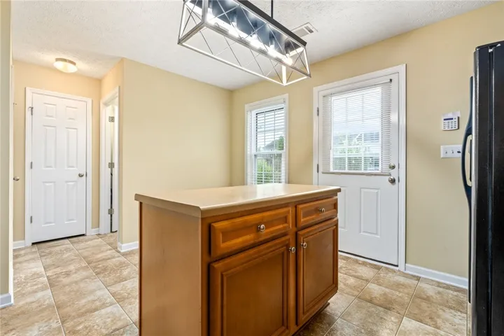 A functional kitchen with a central island offers ample counter space and convenient access to the outdoors.