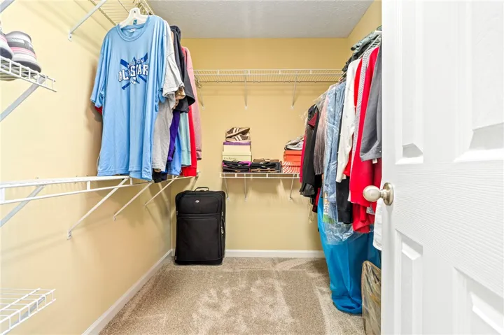Ample storage solutions are provided by the organized wire shelving system in this Walk-In Closet.