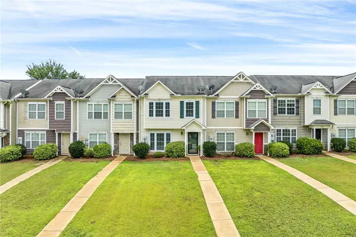 A row of charming townhomes showcases well-maintained lawns and individual walkways, creating inviting curb appeal.