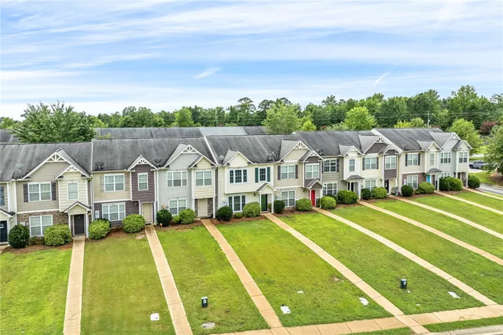 A community of attractive townhomes with tidy green lawns and mature landscaping.