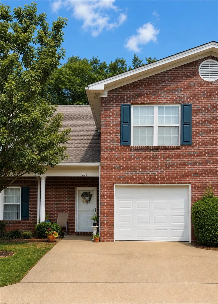 Brick facade with a prominent garage and a covered entryway welcomes residents home.