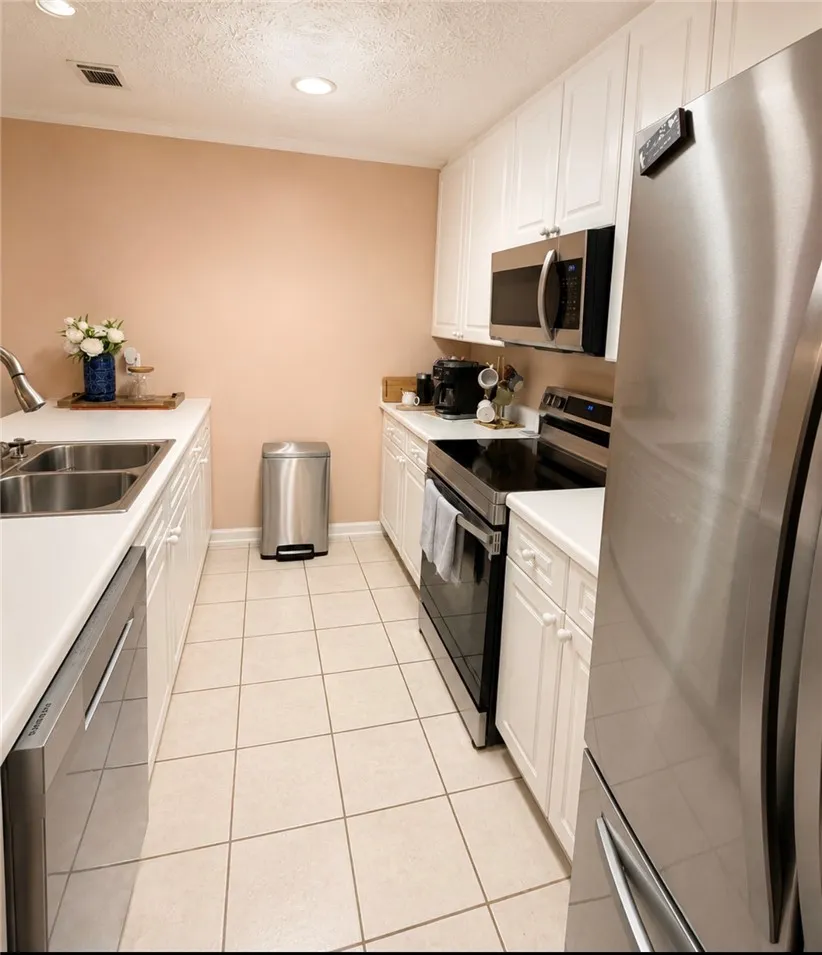 A streamlined galley kitchen with pristine white cabinetry, offering seamless meal preparation.