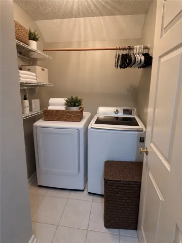 Efficient laundry area features a convenient hanging rod and practical shelving.