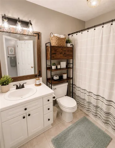 A well-appointed bathroom with a spacious vanity, framed mirror, and a convenient storage unit over the toilet.