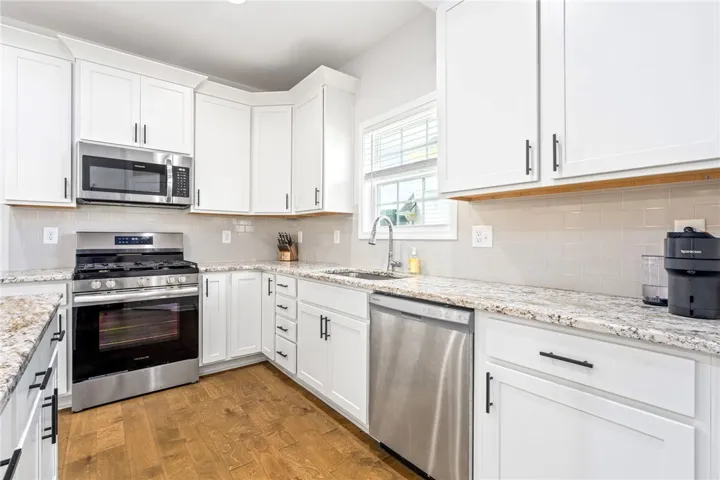 Kitchen with white cabinets & a window over the sink