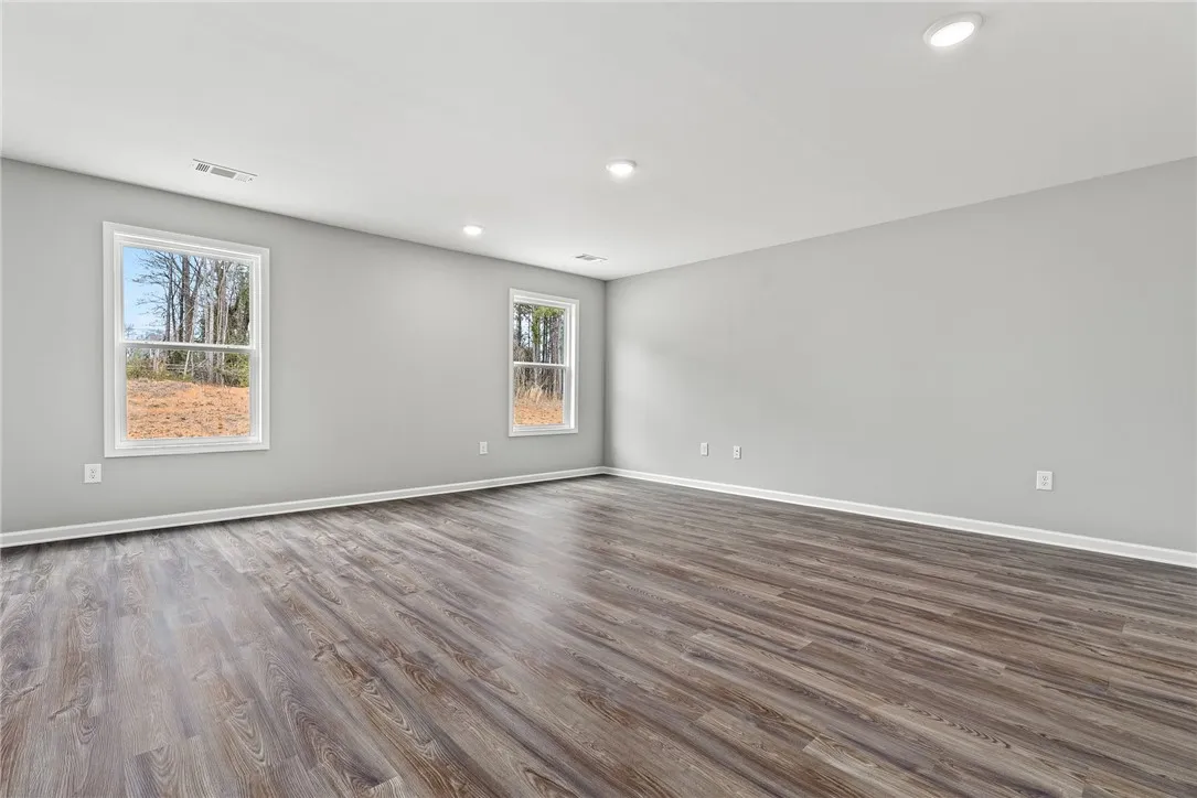 Natural light pours into this spacious room, highlighting the contemporary flooring and inviting ambiance.