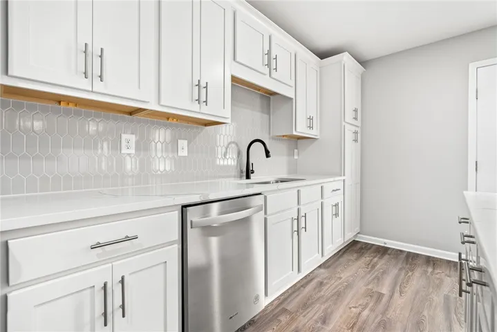 A well-appointed kitchen features crisp white cabinetry, modern hardware, and sleek stainless steel appliances.