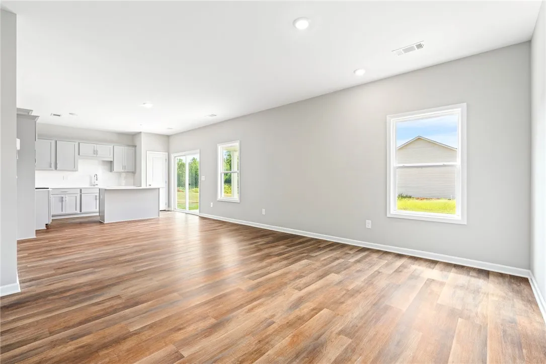 Gleaming wood floors anchor this expansive open living area connecting seamlessly to the kitchen.