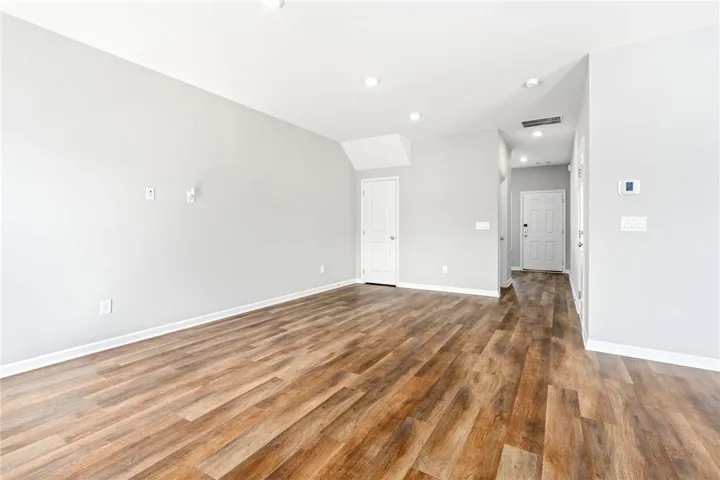 Rich wood-inspired flooring anchors a spacious open living area with clean-lined architecture.