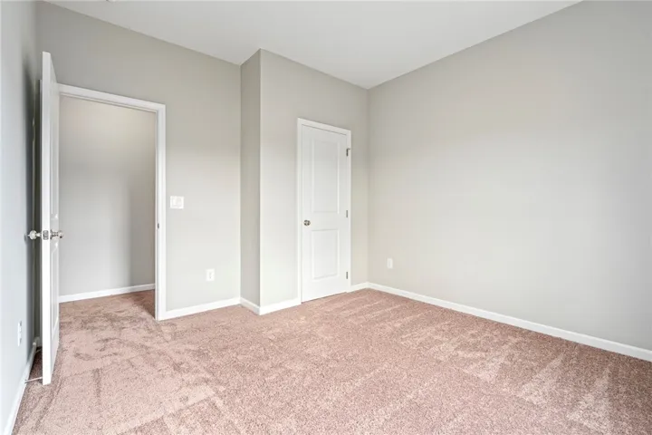 Plush carpeting anchors this versatile room featuring crisp trim and smooth walls.