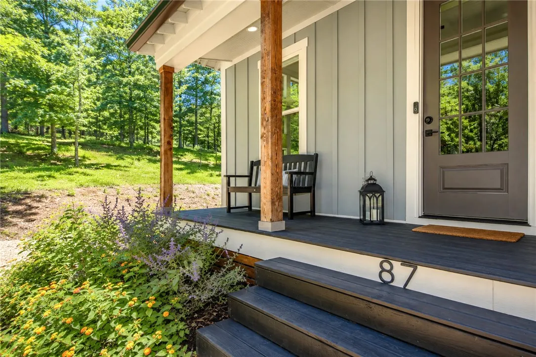A tranquil front porch with wooden columns offers a peaceful entry to this inviting home.