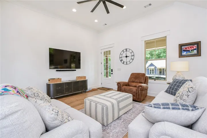 An open living area boasts high ceilings and durable hardwood flooring.