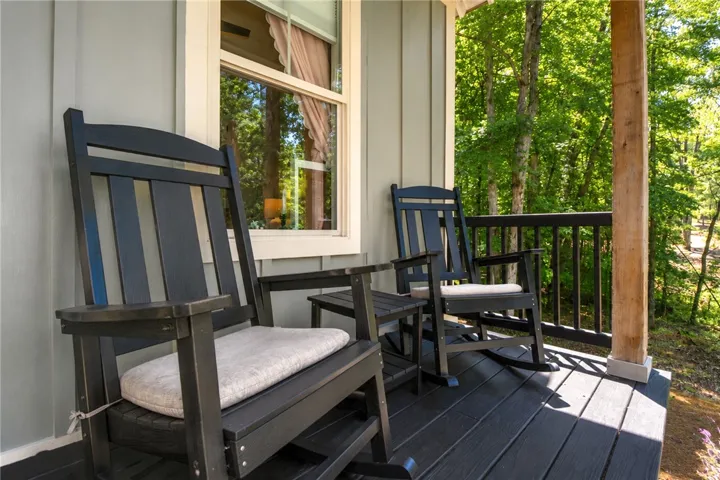 A tranquil wood-planked porch, perfect for enjoying quiet moments amidst nature's embrace.