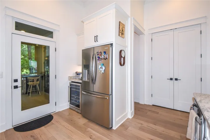 A well-equipped kitchen space features hardwood floors, granite counters, and stainless steel appliances.