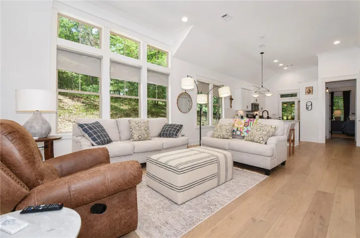 Natural light floods this inviting living area, showcasing rich hardwood floors and an open concept.