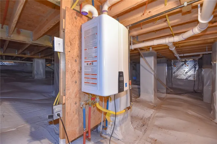 Essential utilities including a tankless water heater are neatly organized within this functional crawl space.