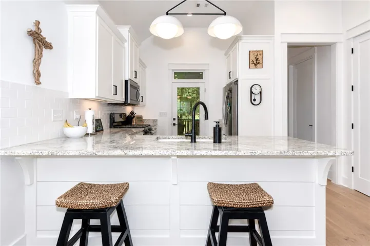 Bright white kitchen with ample counter space and a convenient breakfast bar.