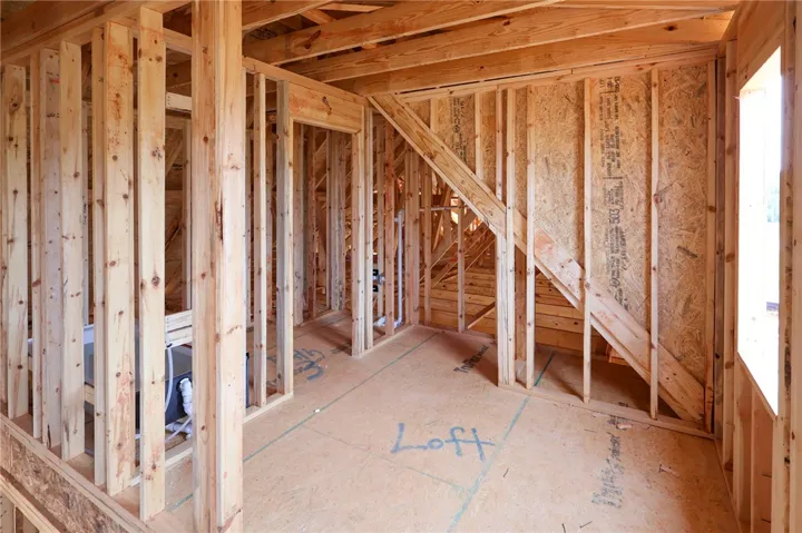 Exposed wood framing outlines the future loft area during the construction phase of this home.