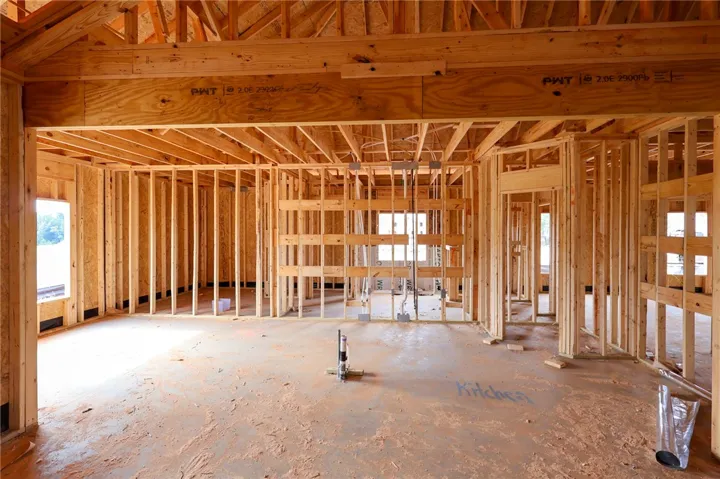 Exposed wood framing and open structural beams outline the future layout of this custom home.