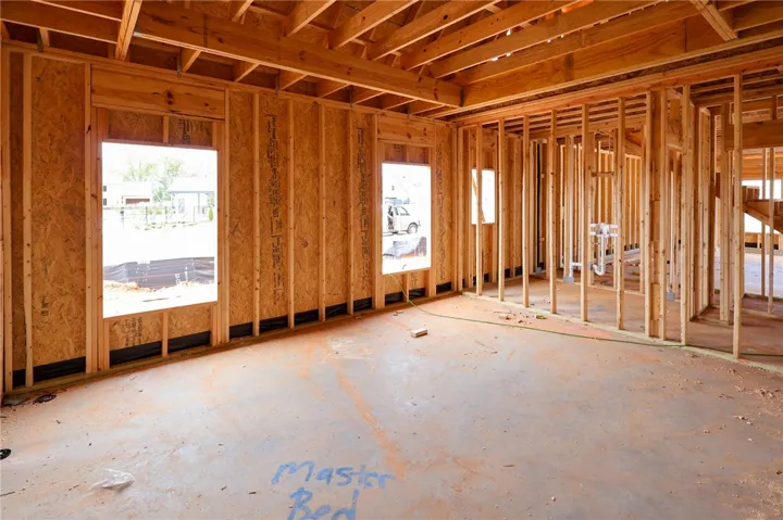 Exposed wood studs and subflooring define this custom bedroom under construction.