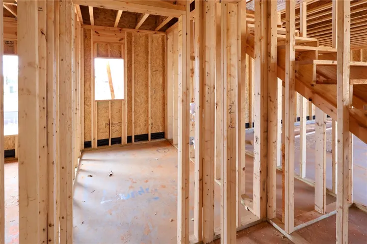 Exposed wood framing and subfloors highlight the sturdy architectural structure of this home under construction.