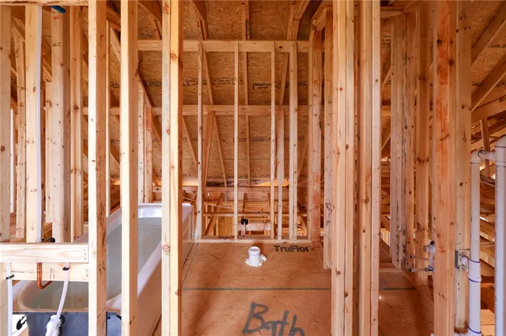 Exposed wood framing and rough-in plumbing highlight this home currently under construction.