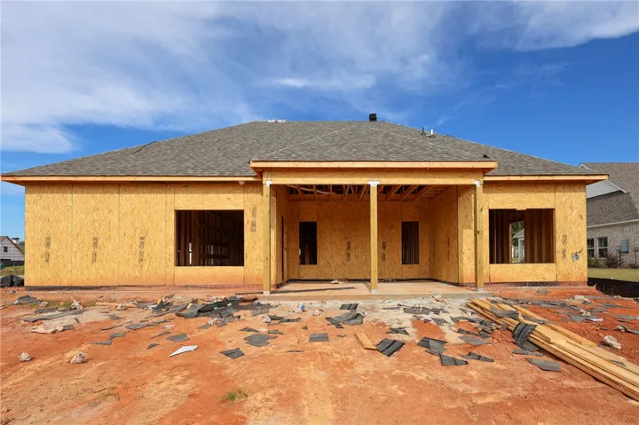 A spacious covered back porch highlights the rear exterior of this home under construction.