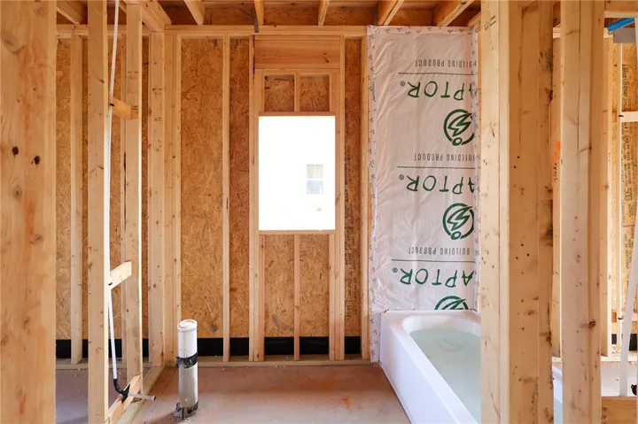 Exposed wood studs outline the layout of a future bathroom under construction.