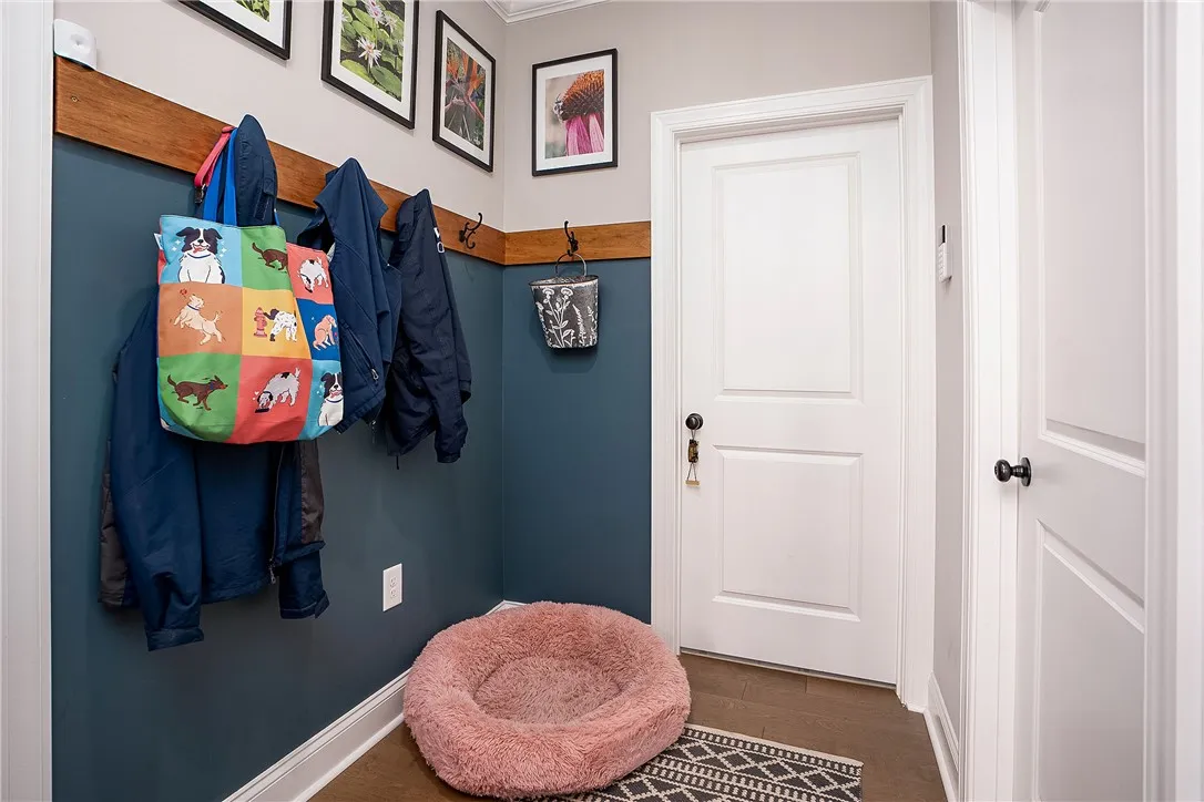 A welcoming entryway with rich wood flooring and a convenient coat rack.