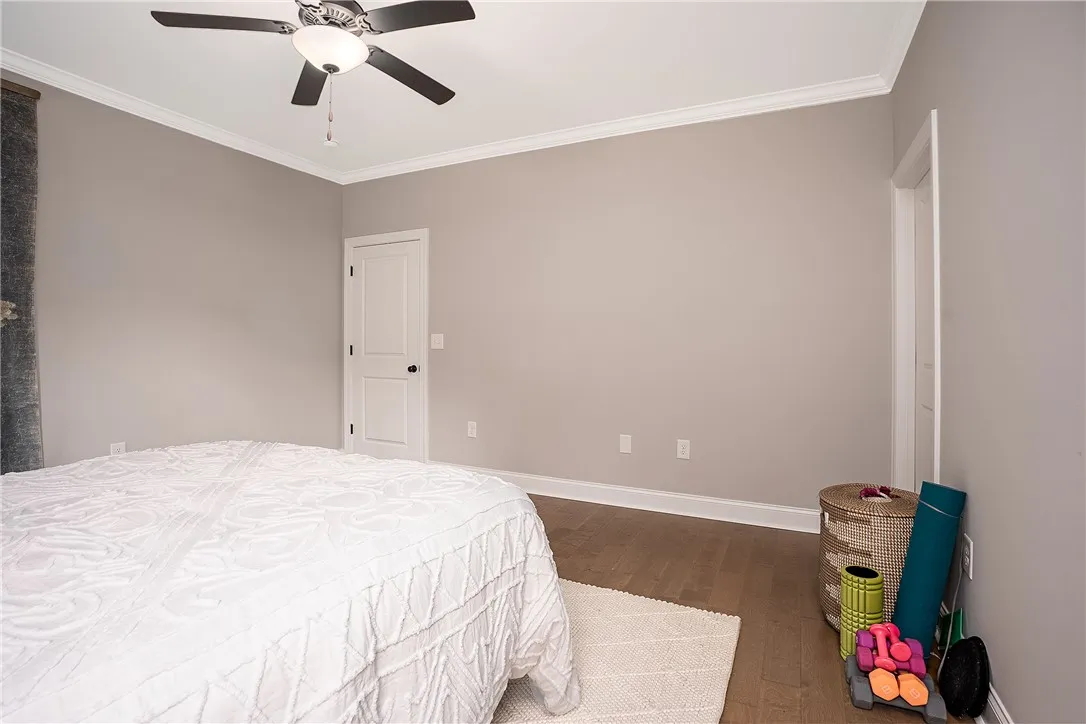 Hardwood floors and crisp crown molding frame this inviting, generously sized sleeping area.