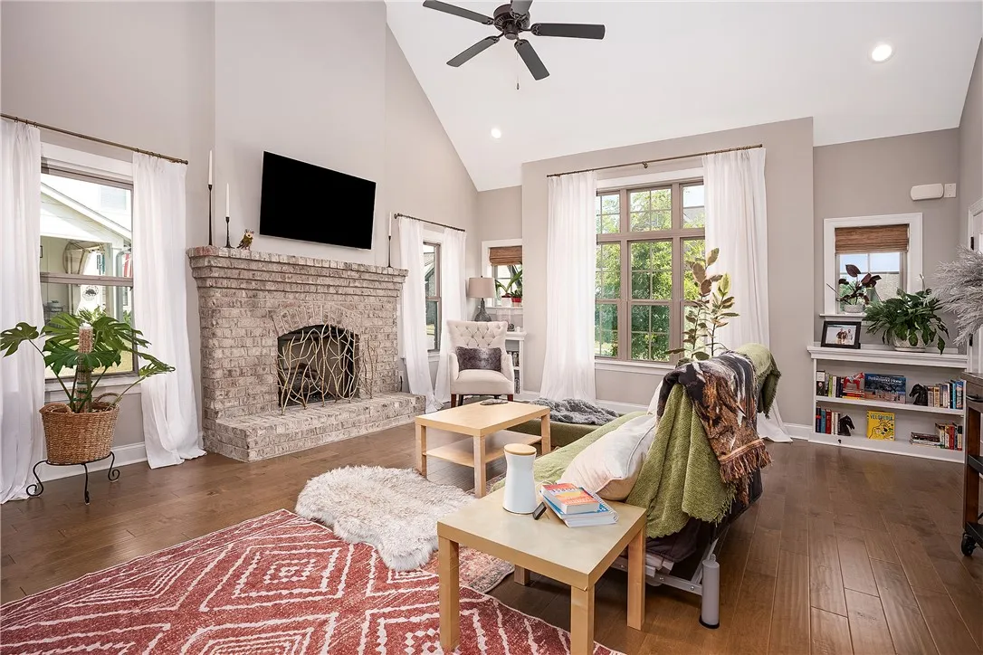 A striking brick fireplace grounds this light-filled great room with soaring vaulted ceilings.