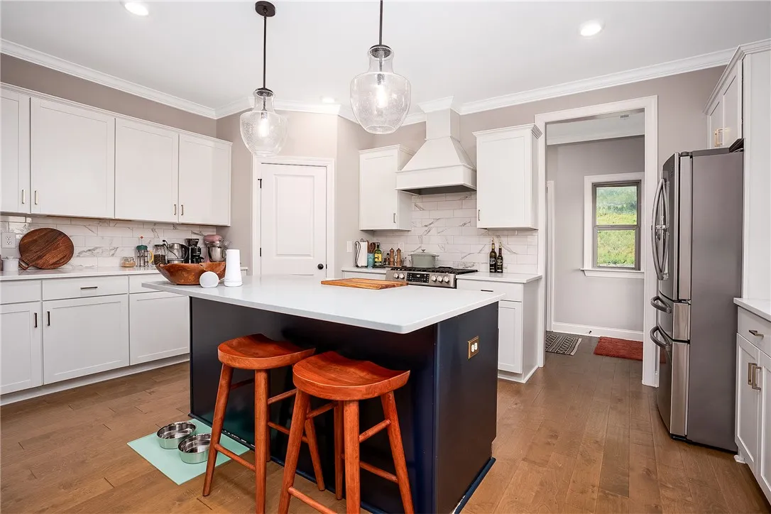 Culinary creativity comes alive in this kitchen, featuring a central island with bar seating and modern fixtures.