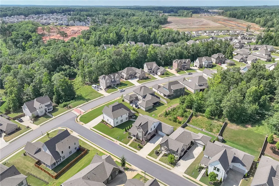 An aerial perspective reveals a flourishing residential neighborhood nestled amidst verdant forests.