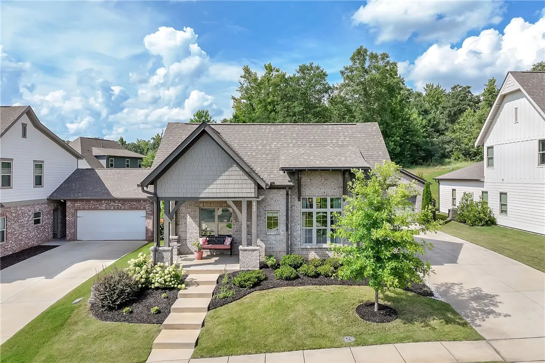 A charming single-family residence with a welcoming front porch and well-maintained landscaping.