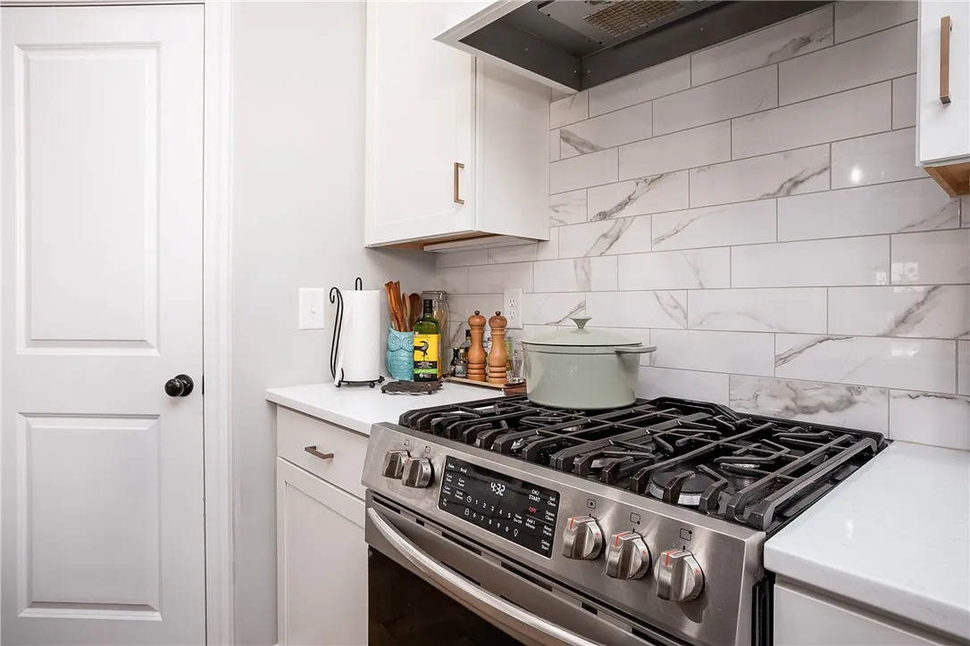 Modern kitchen equipped with a stainless steel gas range and a sleek subway tile backsplash.