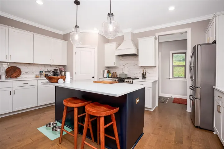 Culinary creativity comes alive in this kitchen, featuring a central island with bar seating and modern fixtures.