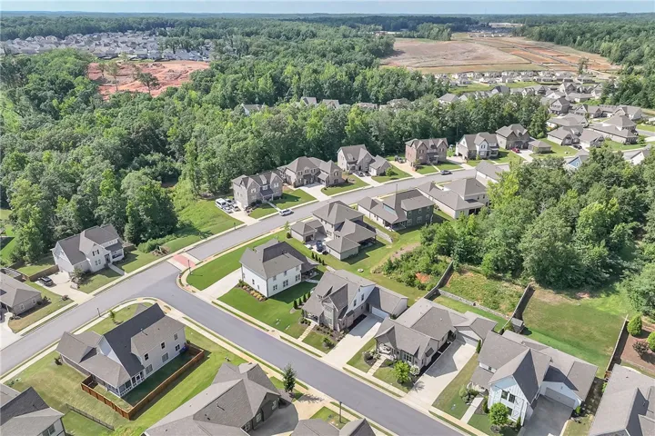 An aerial perspective reveals a flourishing residential neighborhood nestled amidst verdant forests.
