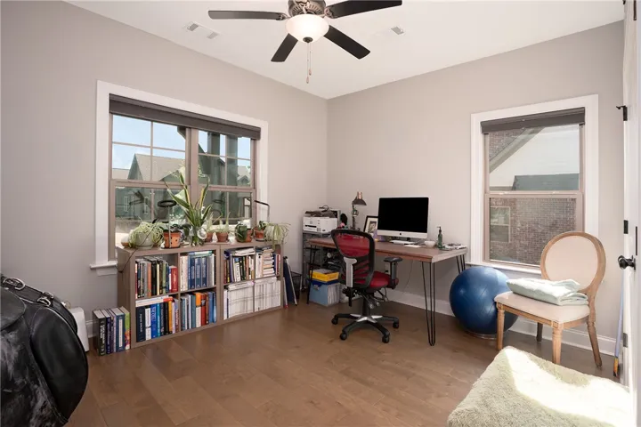 Hardwood floors and generous windows create a naturally lit home office space.