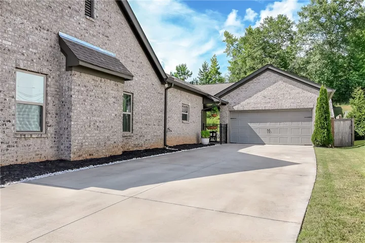 A neatly paved driveway leads to the attached garage, showcasing the home's brick exterior.