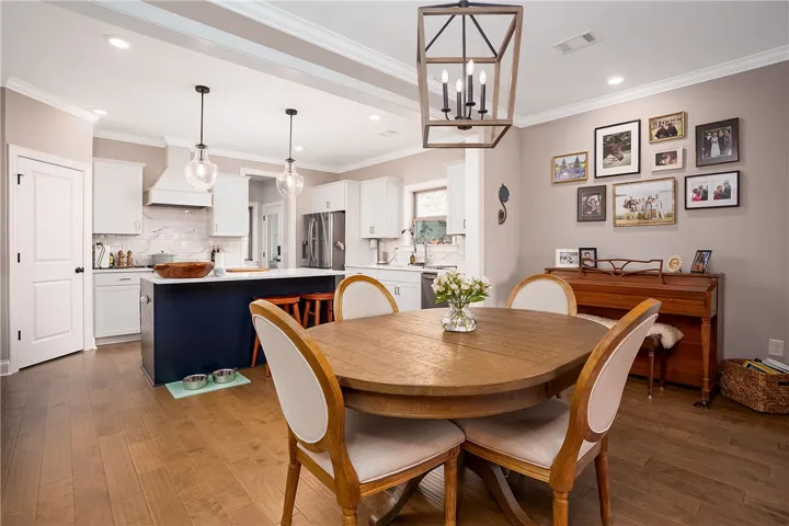 An inviting open-concept kitchen and dining area features rich wood flooring and elegant fixtures.