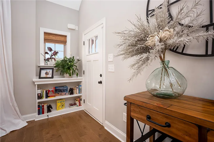 A well-lit entry welcomes guests with built-in shelving and warm hardwood flooring.