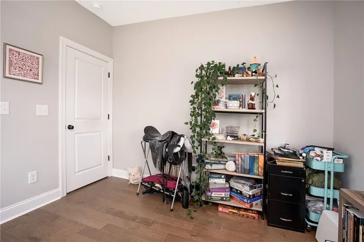 Rich hardwood flooring complements a practical room, perfect for versatile use.