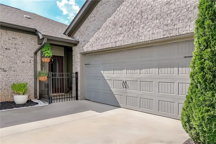 A well-maintained driveway leads to an attached garage, offering convenient entry.