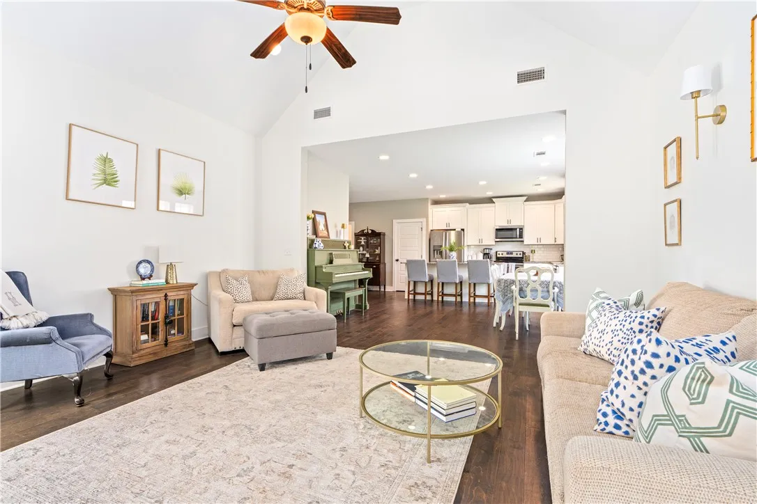 Wood floors flow through this open-concept living area with soaring vaulted ceilings.