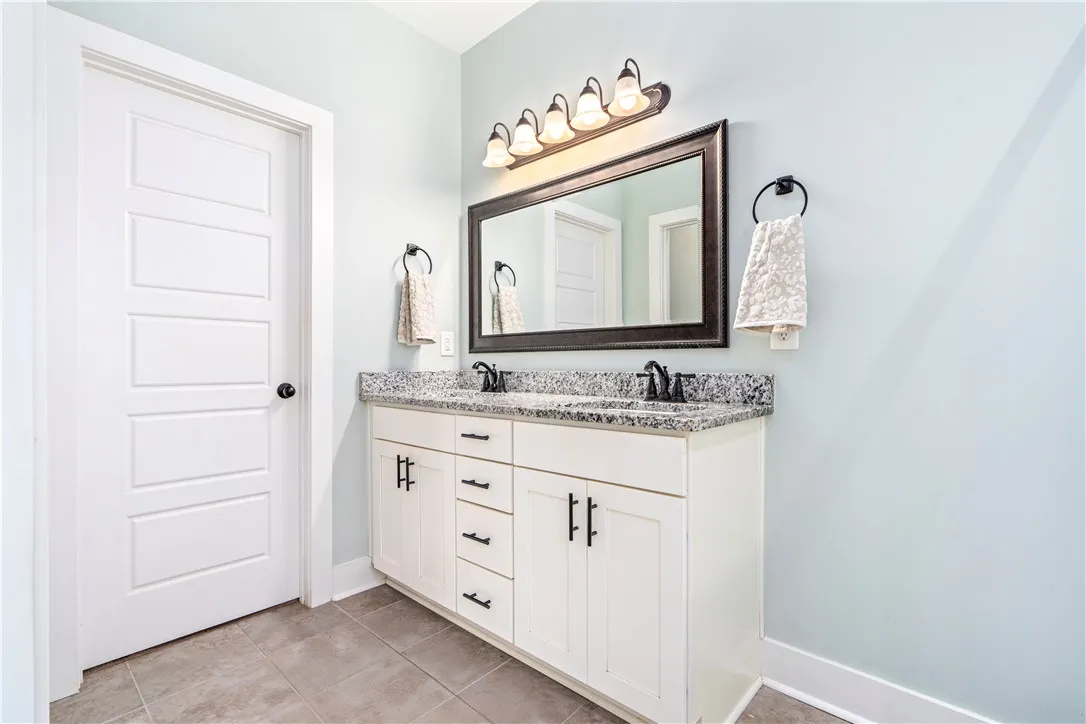 Double vanity with granite counters provides ample space and functionality.