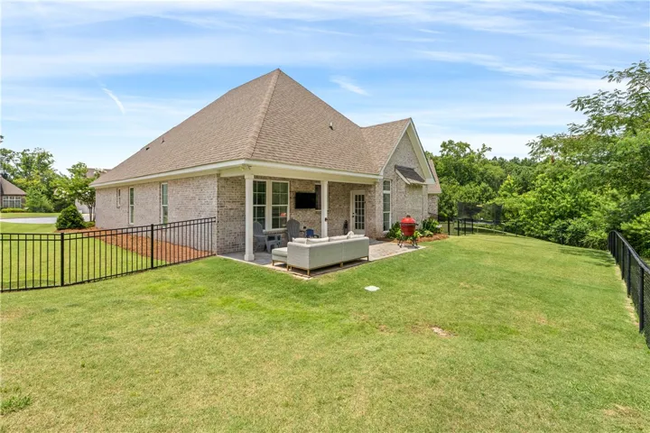 Enjoy outdoor living on this covered patio, overlooking the fenced backyard.