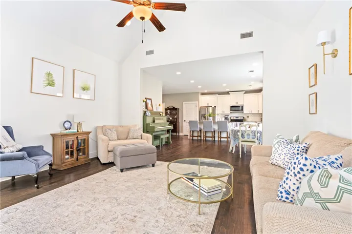 Wood floors flow through this open-concept living area with soaring vaulted ceilings.