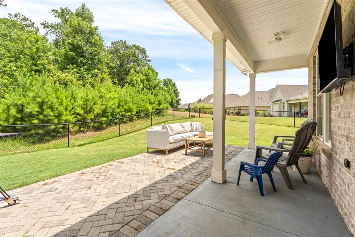A spacious covered patio provides an inviting outdoor living area for relaxation and entertainment.